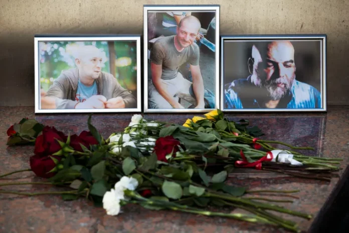 Flores são colocadas em retratos de Aleksandr Rastorguyev, Kirill Radchenko e Orkhan Dzhemal no prédio do Sindicato dos Jornalistas Russos em Moscou, Rússia, quarta-feira, 1º de agosto de 2018. (AP Photo/Pavel Golovkin)